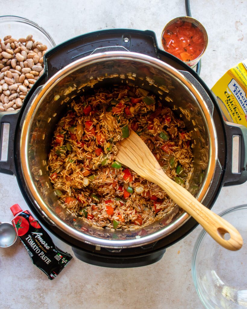 Looking straight down into a pressure cooker with rice and vegetables in the bottom.