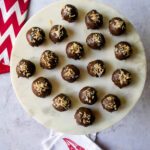 Chocolate Toasted Coconut Balls on a cake stand with a few red and white napkins near by.