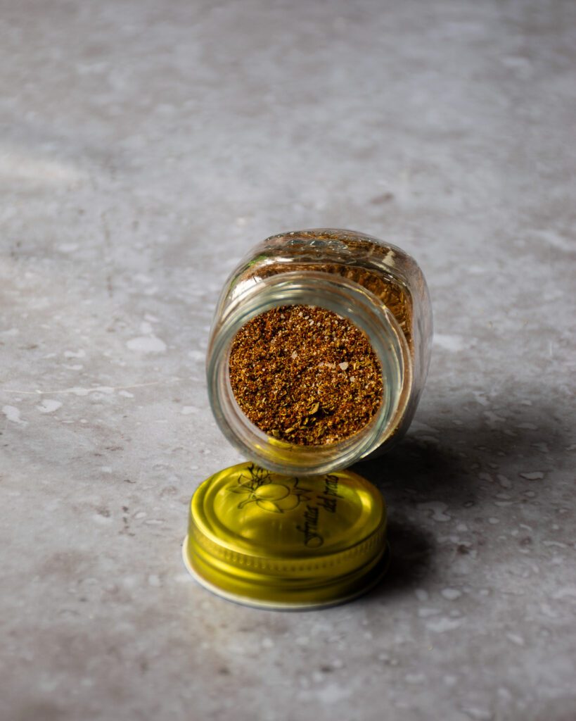 Looking into a jar of homemade taco seasoning on a grey countertop.