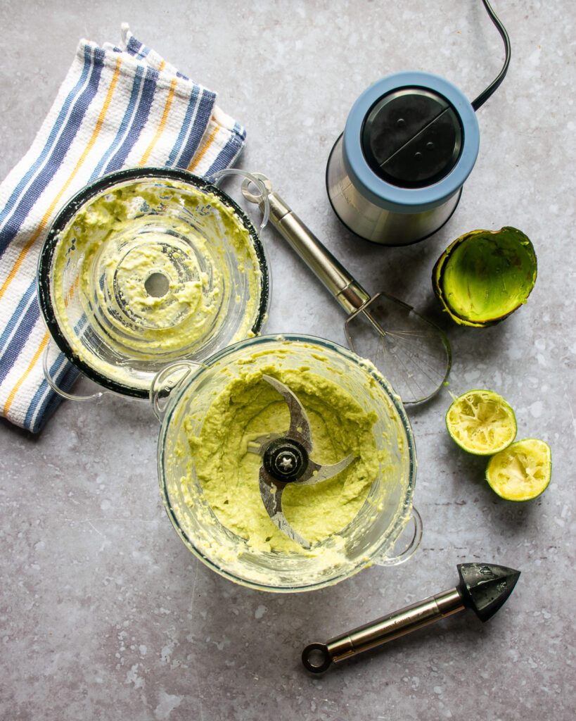 Looking down into a chopper with avocado crema inside.
