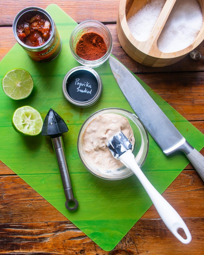 Looking down on chipotle mayo in a bowl with ingredients around.