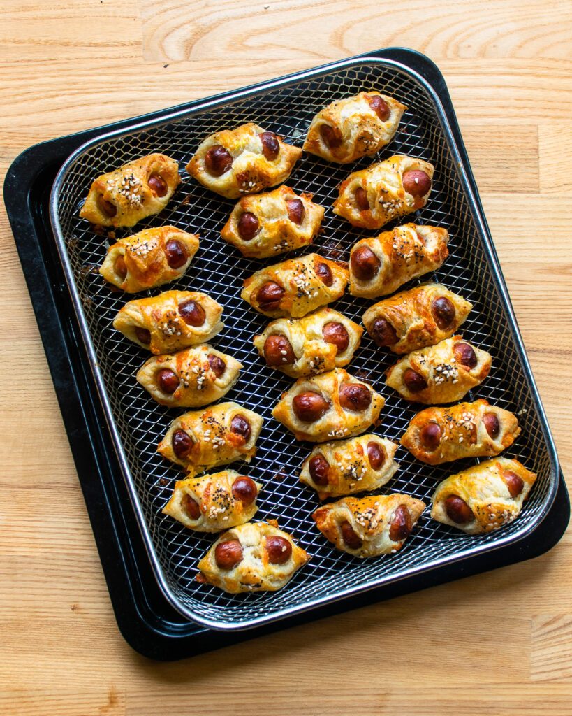 Baked Pigs in a Blanket on an air fryer basket.