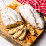 Two loaves of stollen on a cutting board with a few slices cut.