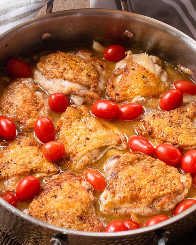 Chicken thighs with white beans and tomatoes before being baked.