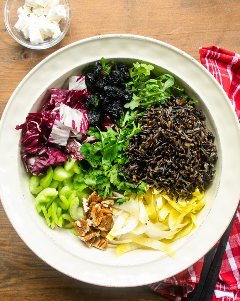 Looking down on a wild rice salad with all the components separated.