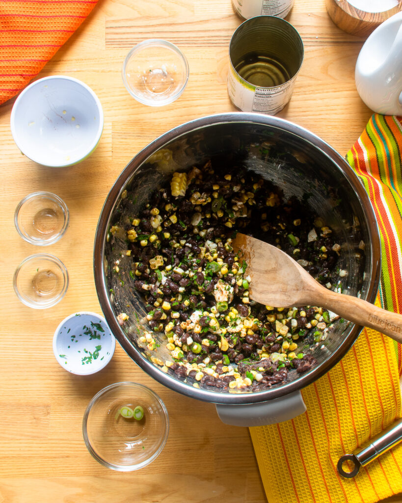 Looking down into a bowl with black beans, corn and other ingredients - black bean enchilada filling.