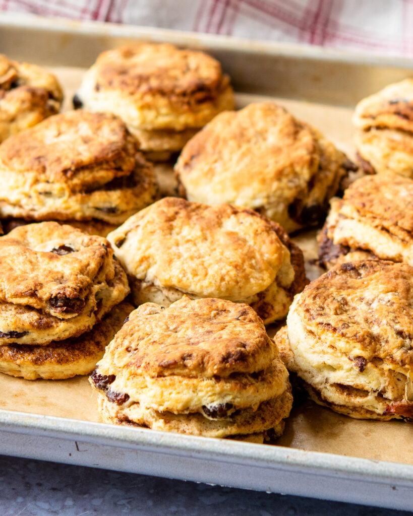 Cinnamon raisin biscuits on a baking sheet.