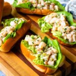 Shrimp rolls on a wooden cutting board.